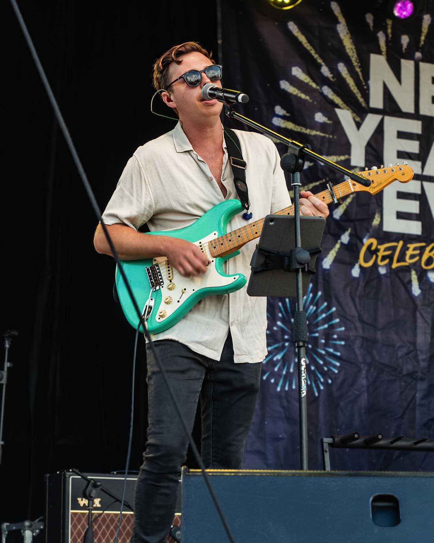 Blue Vinyl guitarist performing on stage at a New Year's Eve celebration